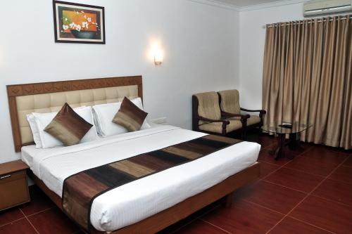 ChakkarakkalBROAD BEAN Chakkarakkal的酒店客房带一张大床和一把椅子