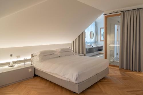 穆里CASPAR Swiss Quality Hotel的一间白色卧室,配有床和一间浴室
