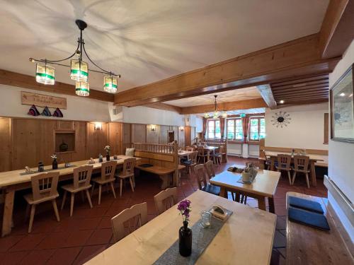 基姆湖畔贝尔瑙Gasthaus Kampenwand Bernau的空的饭厅,配有桌椅