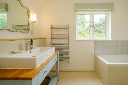 奥尔德堡Greenacres - Aldeburgh Coastal Cottages的一间带水槽和卫生间的浴室以及窗户。