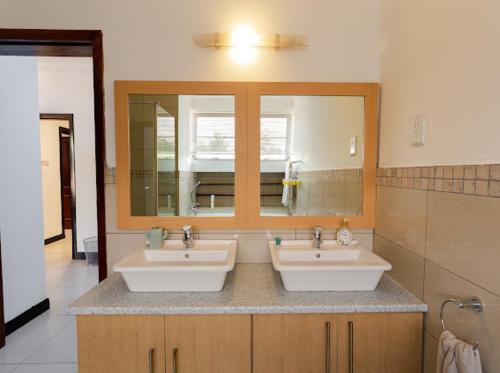 阿克拉Unit 5, Capella Place的浴室设有2个水槽和镜子