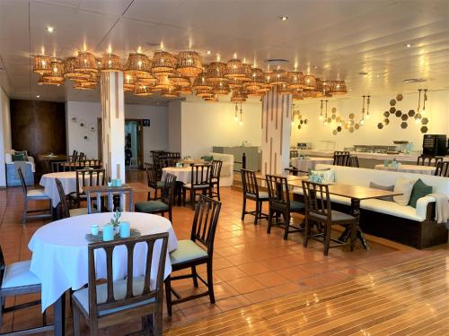 丰沙尔大金塔德弗兰卡酒店的用餐室配有桌椅和吊灯。