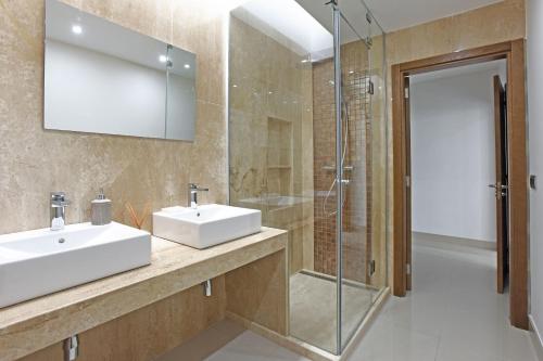 莫甘Villa Morro del Guincho 27的一间带两个水槽和玻璃淋浴间的浴室