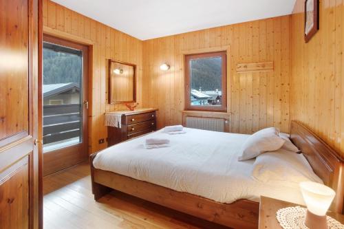 瓦尔迪索托Mountain Chalet close to Bormio的一间卧室设有一张床和木墙