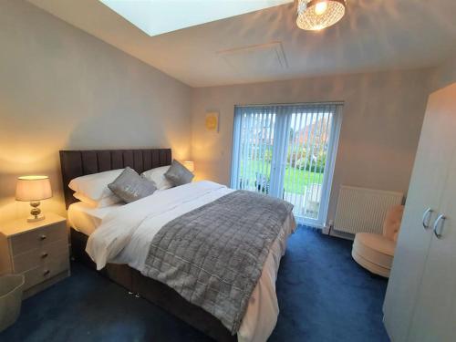 LincolnshirePriory Annex Guest Accommodation Lincoln的一间卧室设有一张大床和一个窗户。