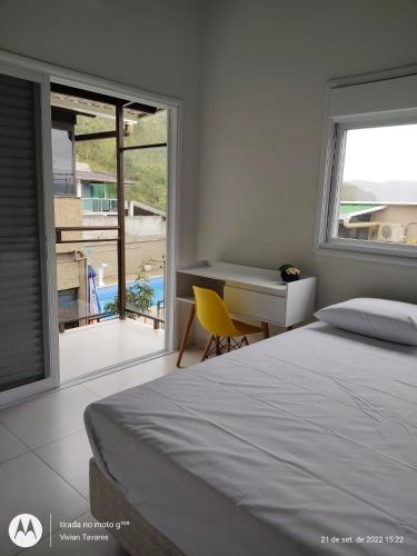 卡拉瓜塔图巴FRANCIS HOTEL MAR的一间带一张床和一张书桌的卧室以及一个阳台