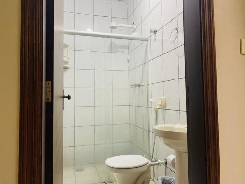 欧里尼奥斯Ouro Hotel的白色的浴室设有卫生间和水槽。