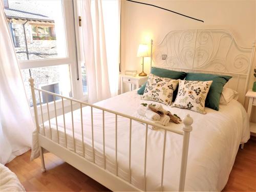AdrallNoa Apartment En el corazón de los Pirineos的卧室配有带枕头的白色床和窗户。