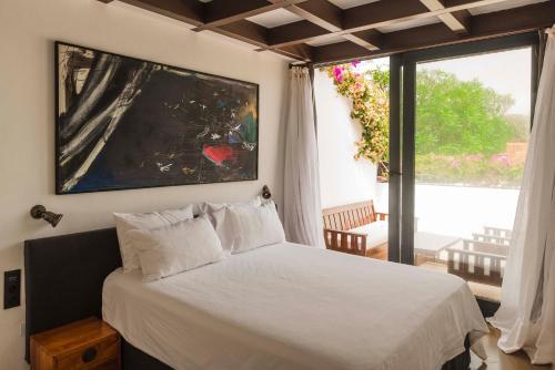 法马拉Casa Sua的一间卧室设有一张床和一个大窗户