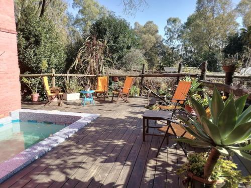 科洛尼亚-德尔萨克拉门托La Estancia hostel的一个带椅子的甲板和一个游泳池