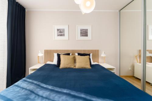 科沃布热格Przystań Koło Brzegu的一间卧室配有一张带两盏灯的大蓝色床。