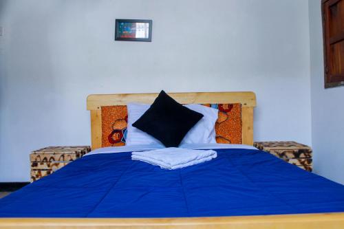 KisoroMotel Santaviva的一张带蓝色毯子和枕头的床