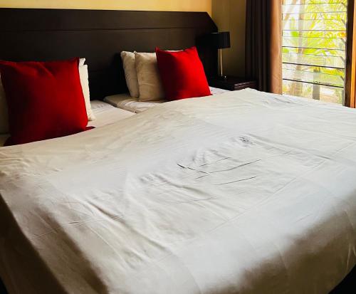 圣卢西亚23 St Lucia Sands的一张大白色的床,上面有红色枕头