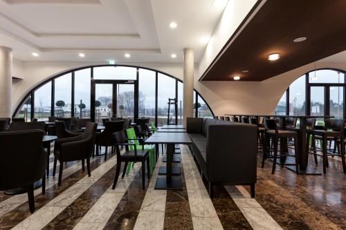 本斯海姆托巴肯酒店的餐厅设有桌椅和大窗户。