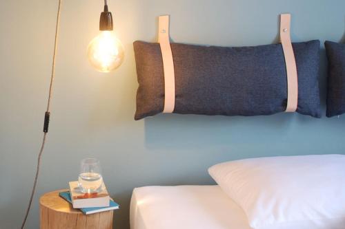 美茵河畔哈瑙Backsteinhaus Hanau的一间卧室配有一张床、一盏灯和一张边桌
