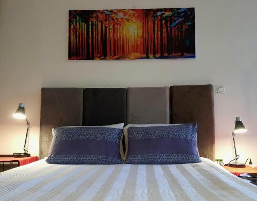 塔里哈Studio Mirador, todo lo que necesitas para disfrutar的一张带两个枕头的床和墙上的绘画
