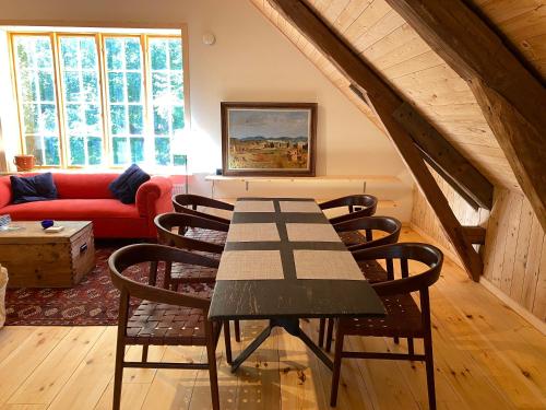 玛丽费莱德Spectacular 6-bed house in beautiful manor park的客厅配有一张桌子和椅子,客厅配有红色沙发