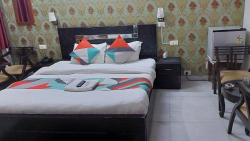 诺伊达Ashray House Noida的一间卧室配有一张带色彩缤纷枕头的大床
