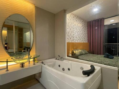 吉隆坡Staycation with Private Jacuzzi @ KL Downtown 1711的带浴缸和镜子的浴室以及一张床