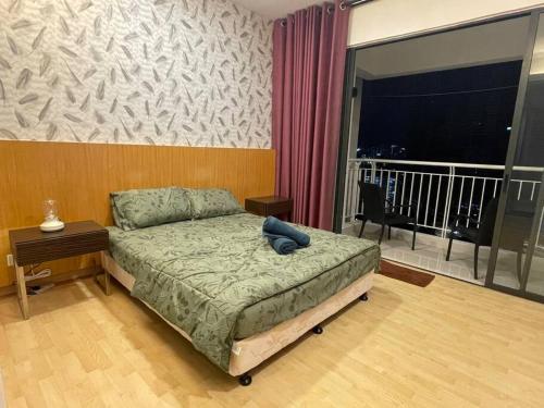 吉隆坡Staycation with Private Jacuzzi @ KL Downtown 1711的一间卧室配有一张床、一张书桌和一个窗户。