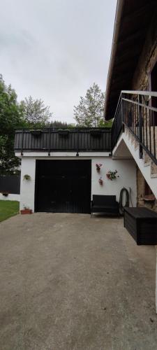 Aránzazu CelayaGreat place, rural environment的车库设有黑色的大门和楼梯