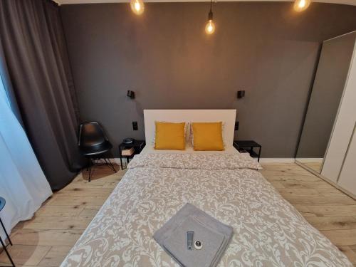弗罗茨瓦夫Tesorio Apartment - AC, Free Parking, WiFi, Business & Family的一间卧室配有一张大床和两个橙色枕头