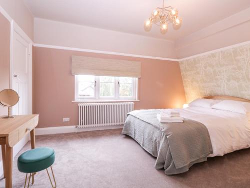 伦敦Barn Hoppitt Lodge的一间卧室配有一张床、一张书桌和一个窗户。