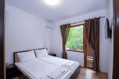 索佐波尔Къща за гости Димови的卧室配有白色的床和窗户。