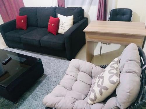 MeruJoshua’s place: cosy furnished one bedroom apt的客厅配有沙发和桌子
