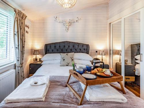 WillingtonLavender Lodge的一间卧室配有一张床铺,桌子上放着一个食物托盘