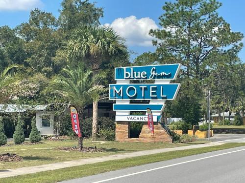 高泉BlueGem Motel的路旁的一个蓝白色汽车旅馆标志