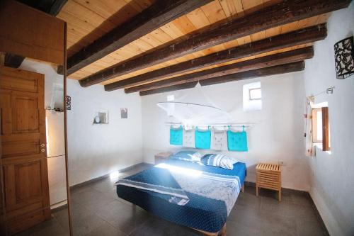 希马拉Rustic Holiday Villa Upper Qeparo的一间卧室设有蓝色的床和木制天花板