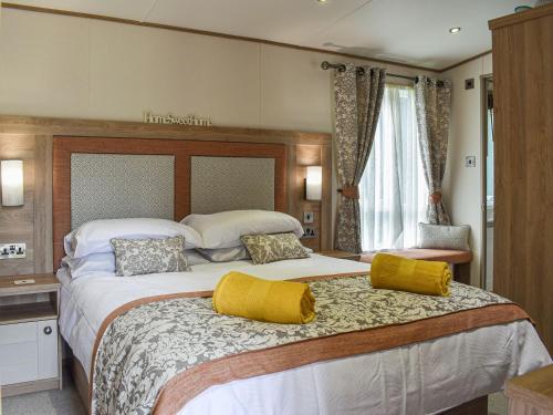 兰福德Deer Glade Lodge的大卧室配有一张带黄色枕头的大床