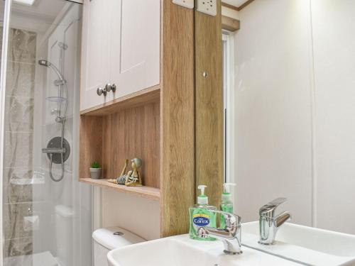 兰福德Deer Glade Lodge的一间带水槽、卫生间和镜子的浴室
