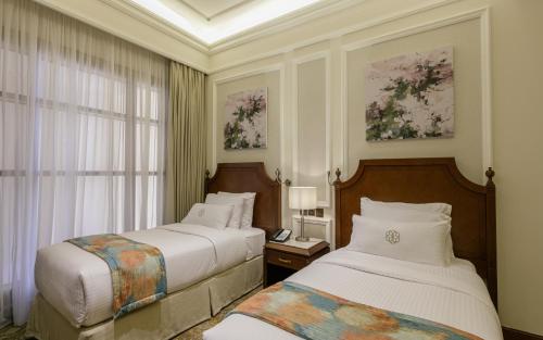 吉达Sunset Jeddah的酒店客房设有两张床和窗户。