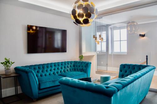克塞洛Ibrahim Boutique Hotel的客厅配有蓝色的沙发和两把椅子