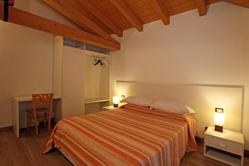 NimisAl Posto Giusto的一间卧室配有一张床、一张桌子和一把椅子