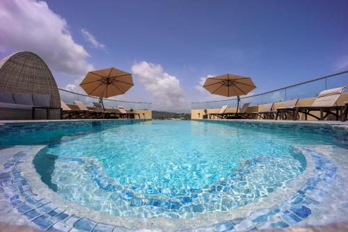Tobago IslandComfort Inn & Suites Tobago的大楼顶部带遮阳伞的大型游泳池
