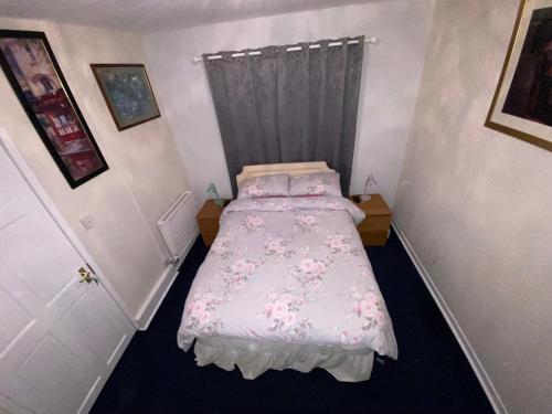 基尔温宁Private Lounge and Double Room的一间小卧室,配有一张带粉红色床单的床