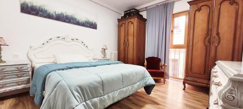 莱昂www SanMartinPlaza es En el corazón del casco histórico的一间卧室配有一张床、一个梳妆台和一扇窗户。