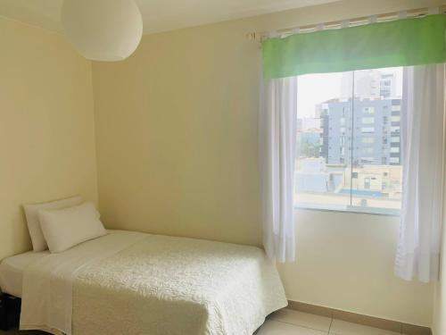 利马Spacious apartment in Miraflores的一间卧室设有一张床和一个窗口
