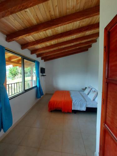 El PeñolDonde Andres Campestre - Guatape的一间卧室设有一张床和一个大窗户