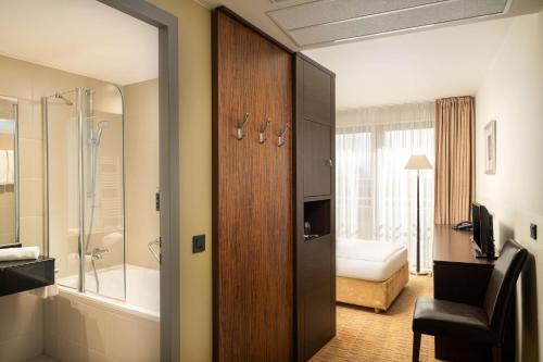 汉堡汉堡芮拉诺酒店的浴室设有推拉门,通往带淋浴的浴室。
