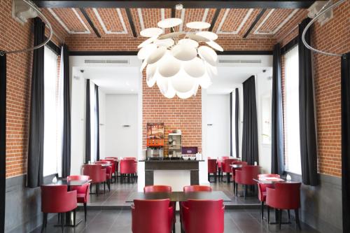 利尔Zimmerhof Hotel的一间带红色椅子和吊灯的用餐室