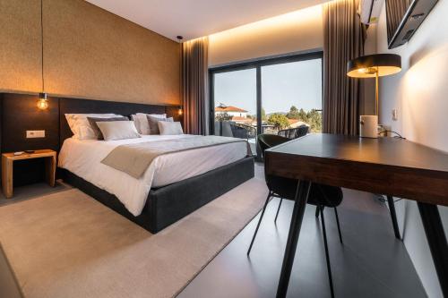 科英布拉Granja da Cabrita的配有一张床和一张书桌的酒店客房