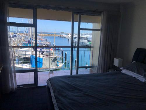 弗里曼特弗里曼特尔港度假屋的卧室配有1张床,享有码头的景致