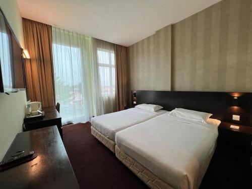 太平SSL商贸酒店的酒店客房设有一张床和一个大窗户