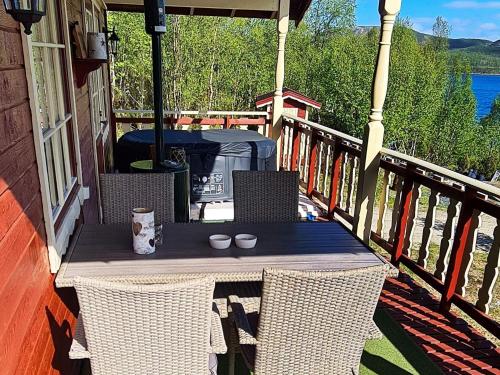 Karpbukt7 person holiday home in JARFJORD的门廊上的桌子,上面有两根蜡烛