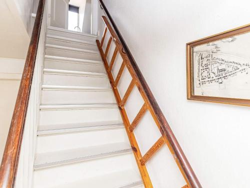 艾勒斯克宾3 person holiday home in r sk bing的墙上挂着照片的房子里的楼梯