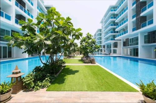 华欣Light, airy, pool views 2 bed 2 bath, free wifi, elect的一座建筑物中央的游泳池